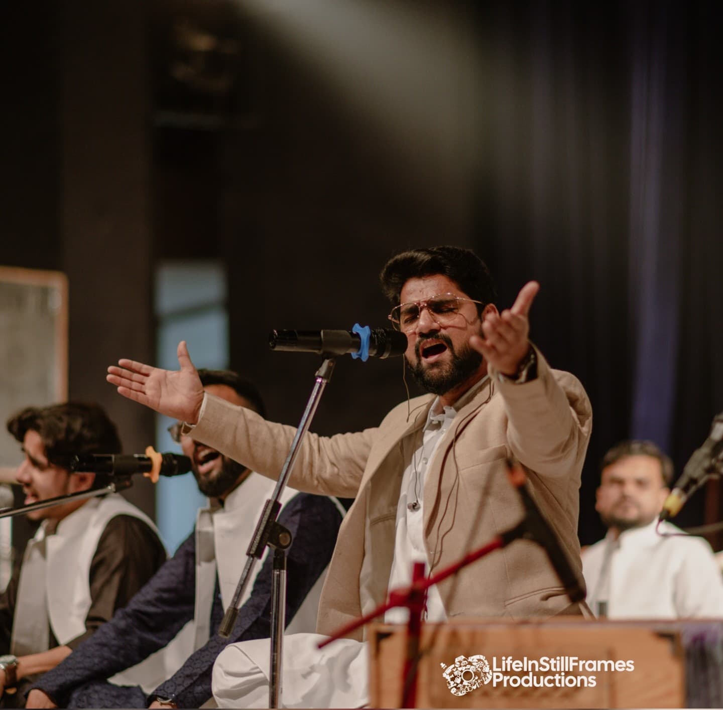 Faizan Ilahi, a renowned Sufi singer from Aligarh, performing on a dimly lit stage, creating a moody and soulful ambiance.